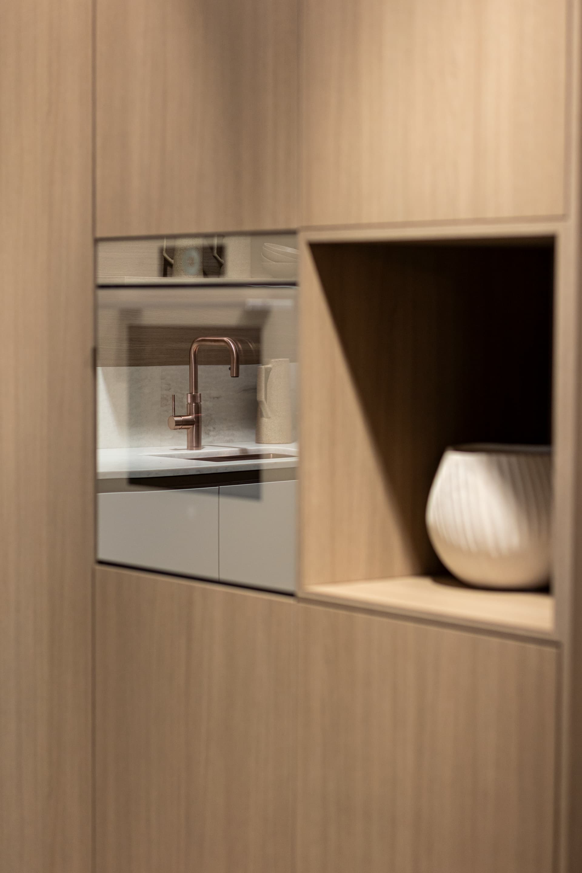 Licht houten keukenkasten met een beige oven