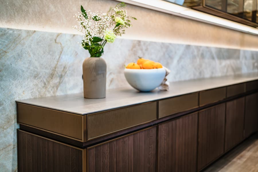 Donker houte keuken met een beige marmer achterwand