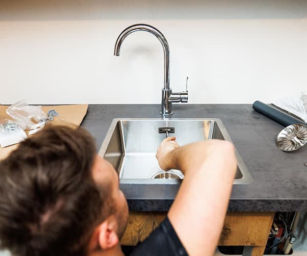 a man is repairing a water tap