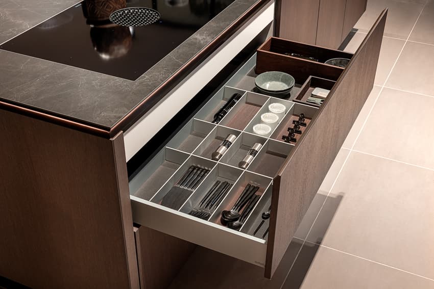 Keukenla in donker houte keuken met een zwart marmer keukenblad