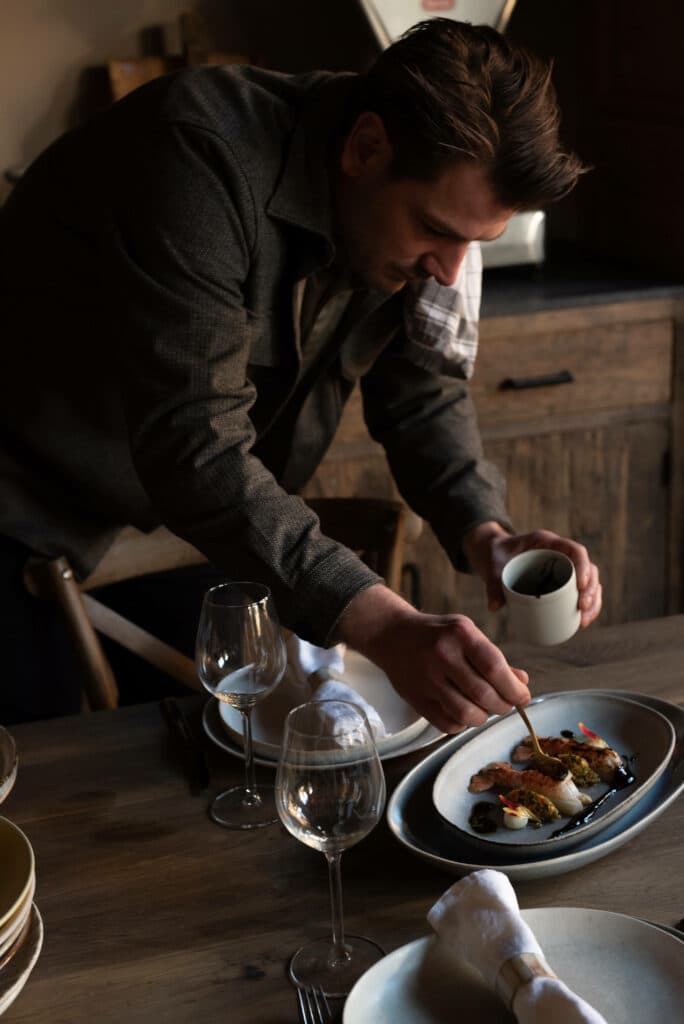 win-private-dining.jpg Kok die een saus over een gerecht op tafel druppelt