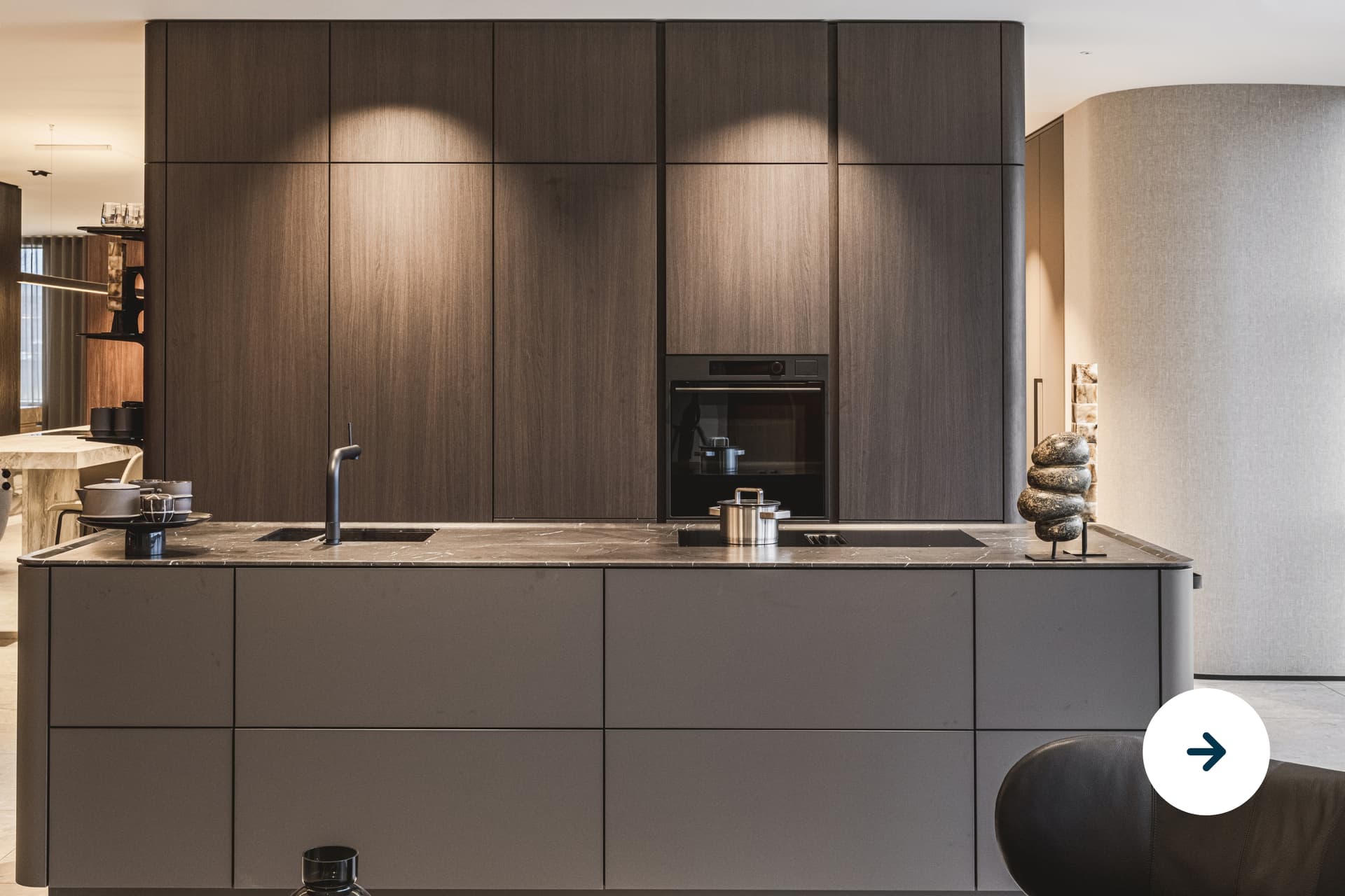 Donker houte keuken met hoge keukenkasten en een kookeiland met bruin marmer werkblad