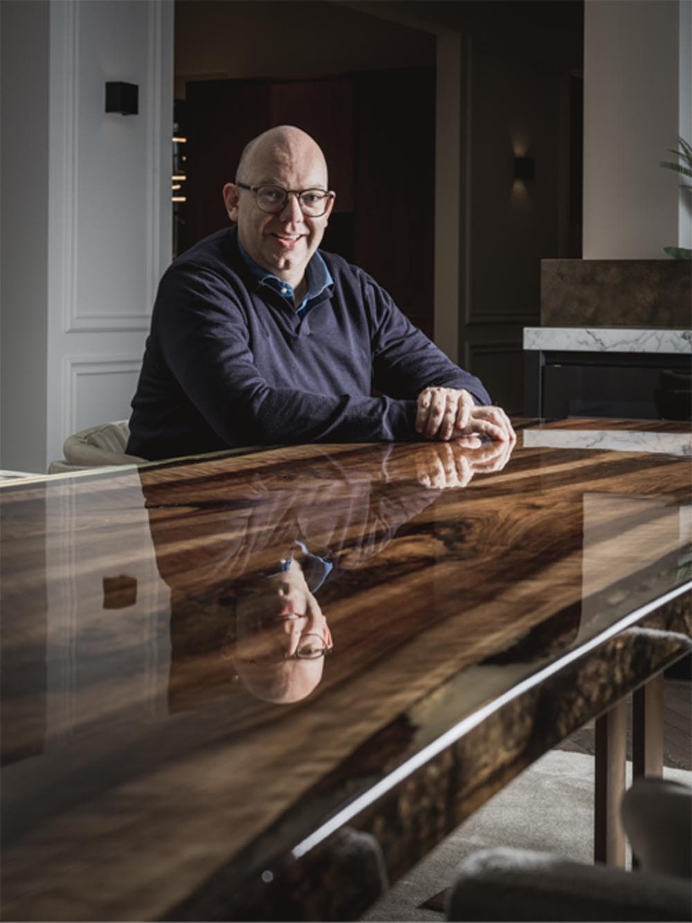 Man aan een lange donker bruine tafel